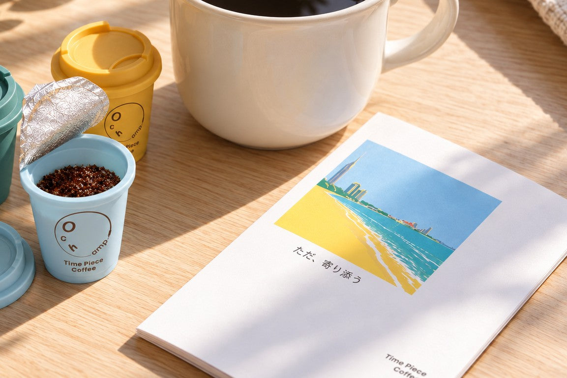 シールを開けた小さなカップと、マグ、エッセイの冊子